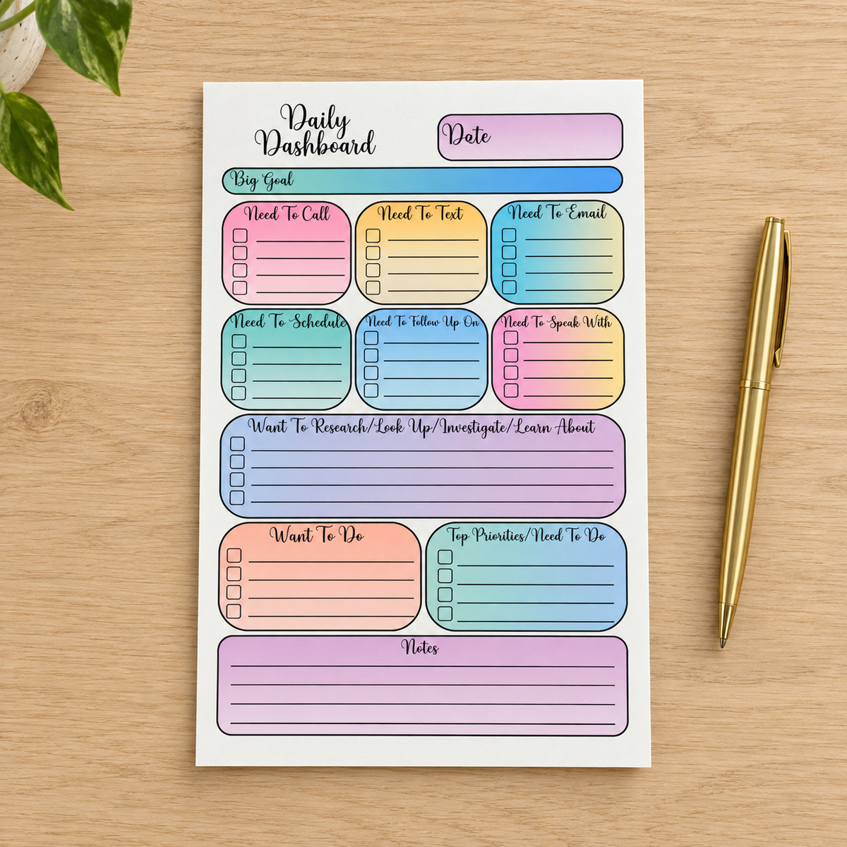Pastel Multicolor Daily Dashboard planning pad with the extra Notes section, displayed on a wood desk beside a gold pen.