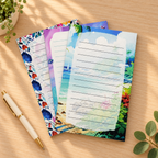 Coastal notepad designs on a warm wood desk. One pad per purchase; props not included.